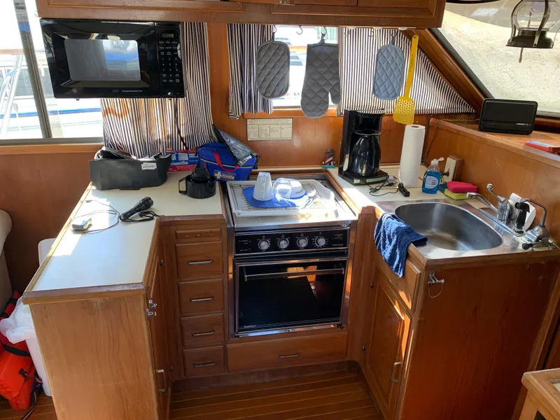Slide: The Image of 1987 Kha Shing Vista 40 yacht kitchen with stove, sink, and microwave. - 9