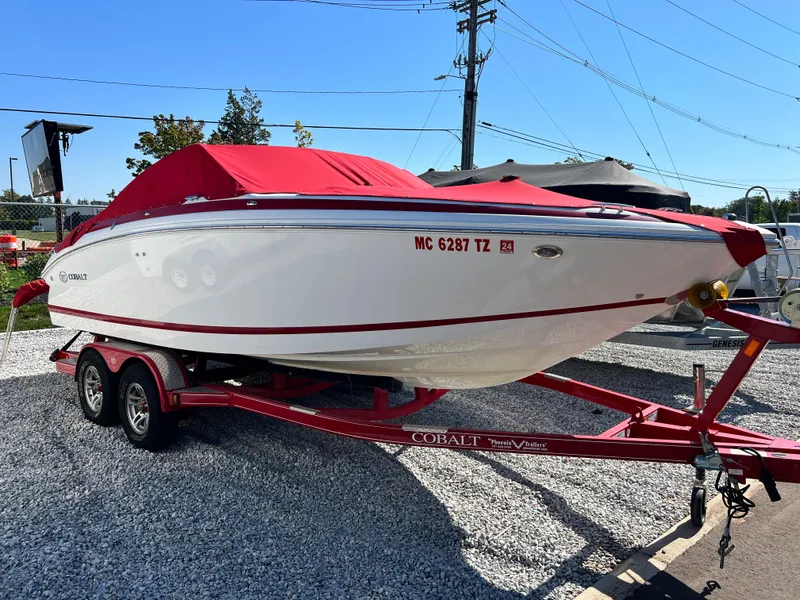 Slide: The Image of 2009 Cobalt 222 boat with red cover on a matching red trailer. - 1
