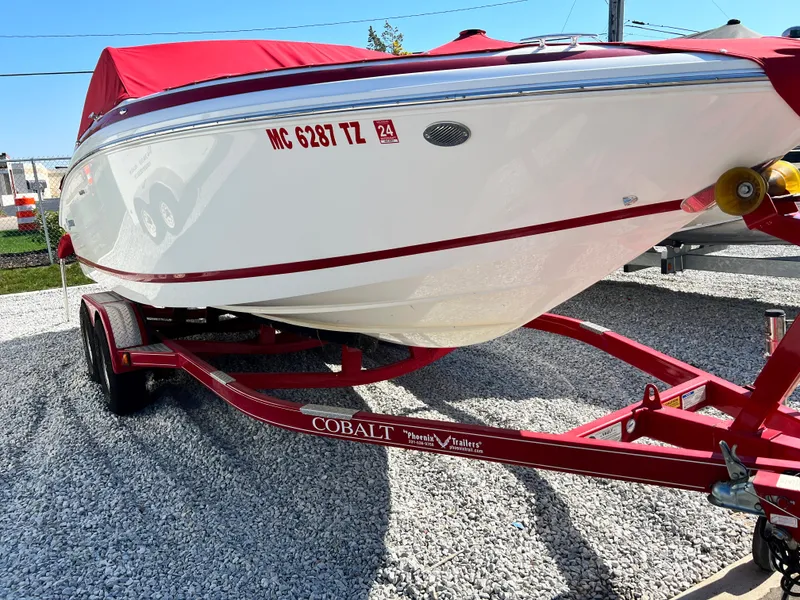 Slide: The Image of 2009 Cobalt 222 boat on a red trailer with a red cover. - 2