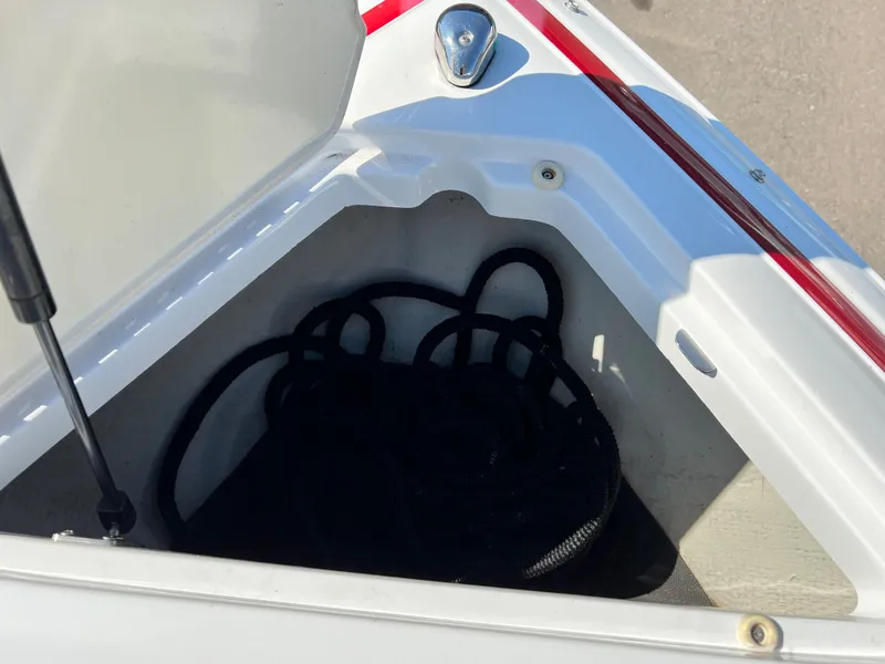 Slide: The Image of 2009 Cobalt 222 boat storage compartment with black rope. - 23