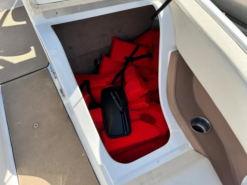 Slide: The Image of Storage compartment with red life jackets in a 2009 Cobalt 222 boat. - 25