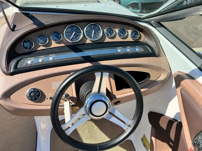 Slide: The Image of 2009 Cobalt 222 boat dashboard with steering wheel and instrument gauges. - 28