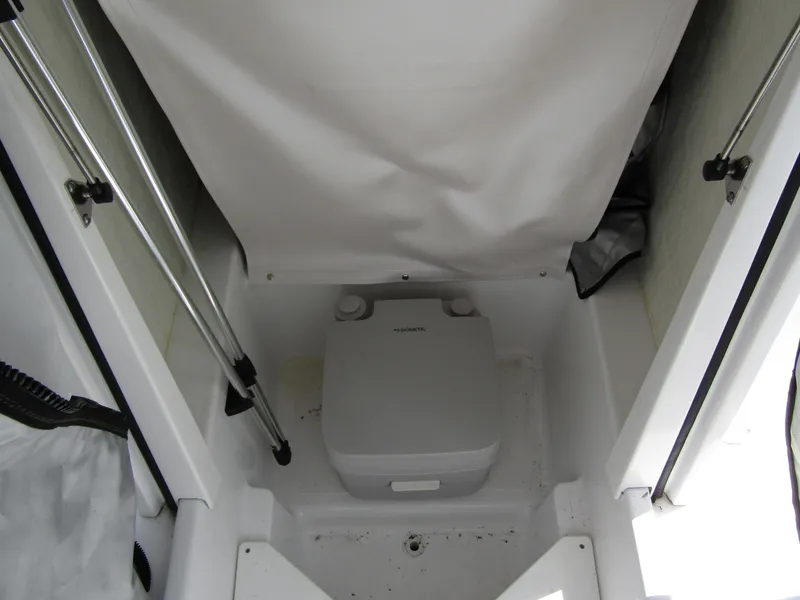 Slide: The Image of 2024 Wellcraft 202 Fisherman boat interior with portable toilet. - 13