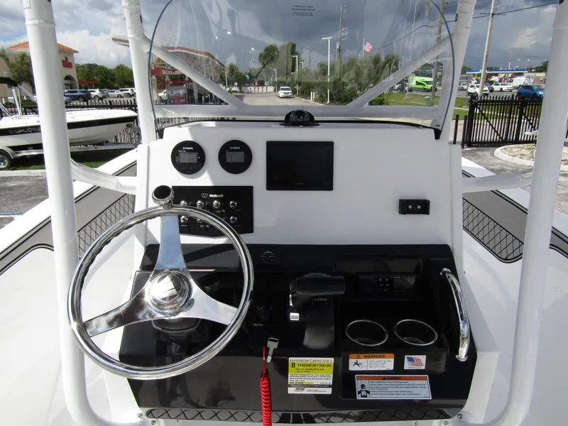 Slide: The Image of 2024 Wellcraft 202 Fisherman boat dashboard with steering wheel and controls. - 15