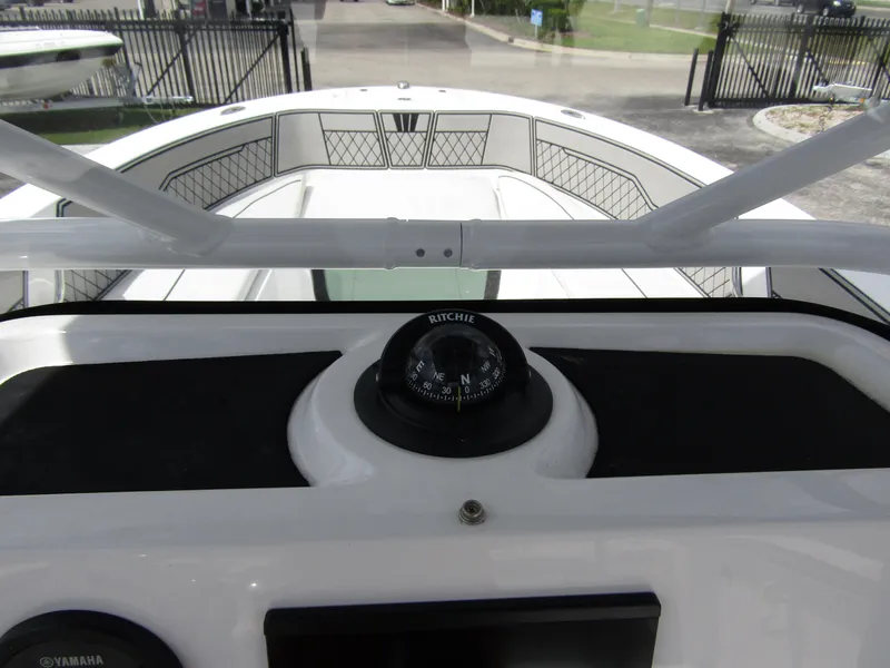 Slide: The Image of 2024 Wellcraft 202 Fisherman boat dashboard with compass and spacious deck view. - 16
