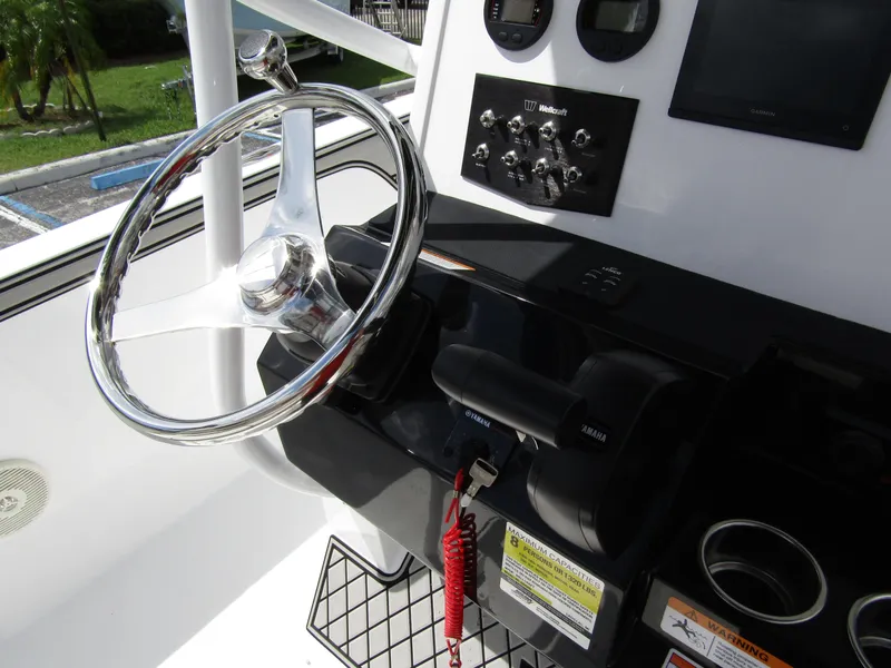 Slide: The Image of 2024 Wellcraft 202 Fisherman boat dashboard with steering wheel and controls. - 20
