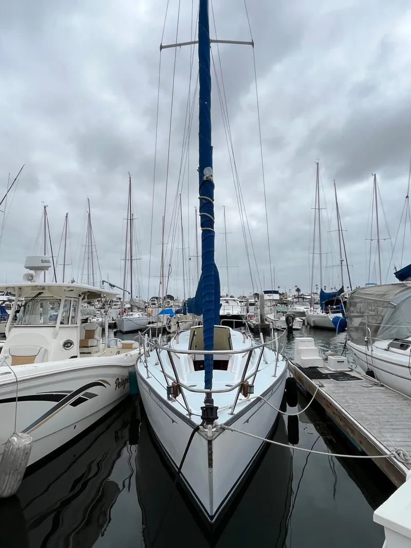 Slide: The Image of Alt text: 1979 Ranger Yachts 30 sailboat docked at marina on a cloudy day. - 1