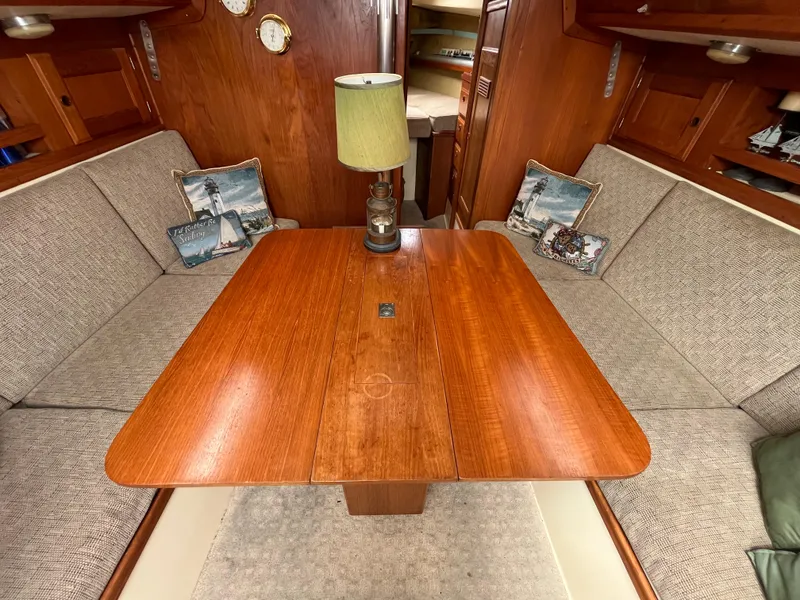 Slide: The Image of 1979 Ranger Yachts 30 interior dining area with wooden table and cushioned seating. - 22