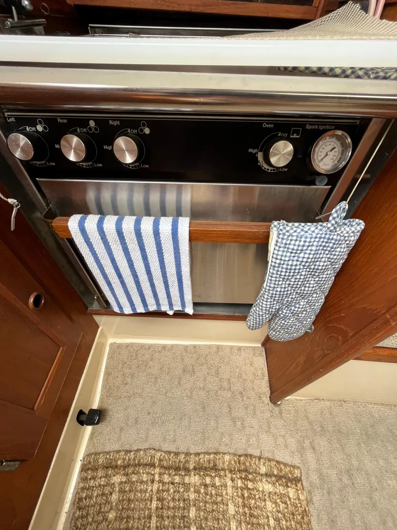 Slide: The Image of 1979 Ranger Yachts 30 kitchen oven with striped towel and checkered oven mitt. - 27