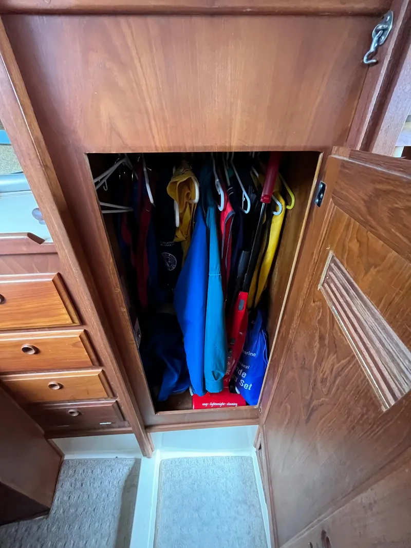 Slide: The Image of Wooden closet in a 1979 Ranger Yachts 30, filled with hanging clothes. - 32