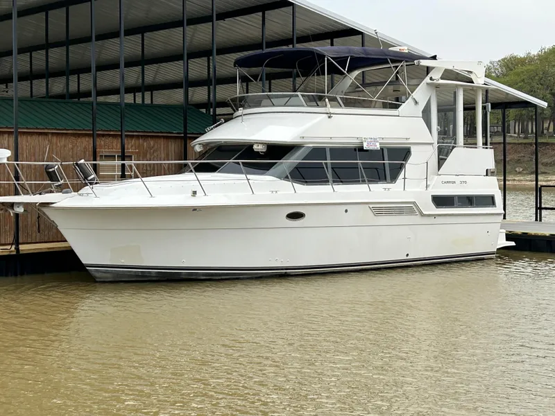 Slide: The Image of 1996 Carver 370 Aft Cabin yacht docked in a marina. - 0