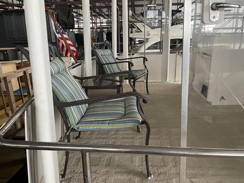 Slide: The Image of 1996 Carver 370 Aft Cabin deck with striped chairs and American flag. - 11