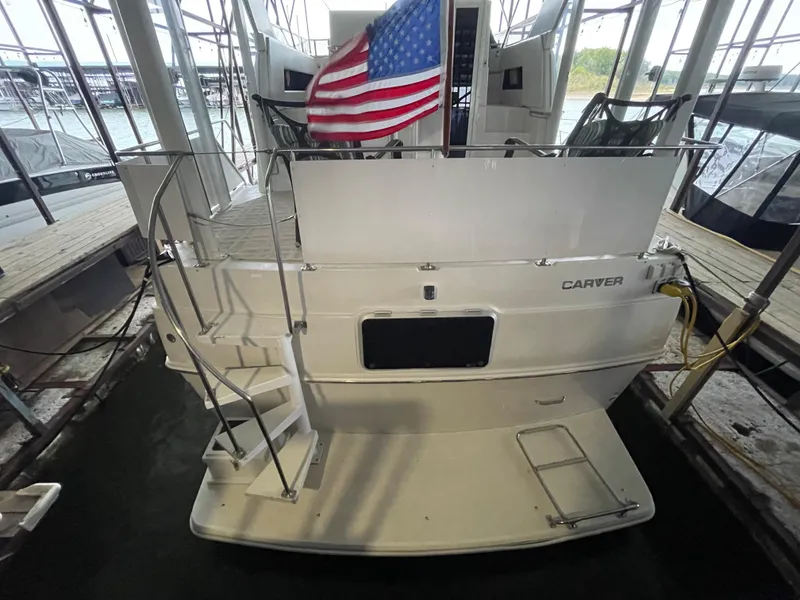 Slide: The Image of 1996 Carver 370 Aft Cabin yacht docked with American flag. - 15