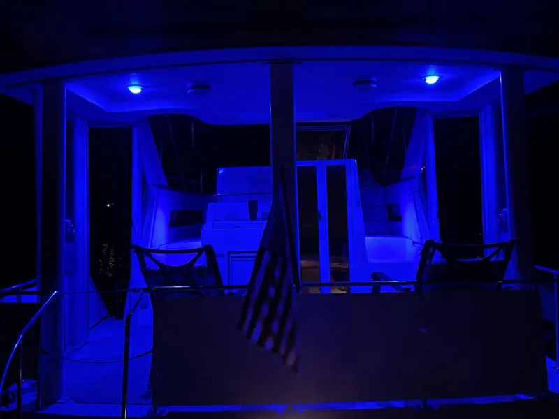 Slide: The Image of 1996 Carver 370 Aft Cabin yacht illuminated with blue lights at night. - 17