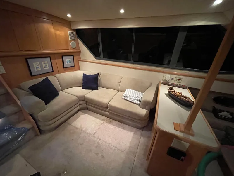 Slide: The Image of Cozy interior of 1996 Carver 370 Aft Cabin with beige sectional sofa and nautical decor. - 29