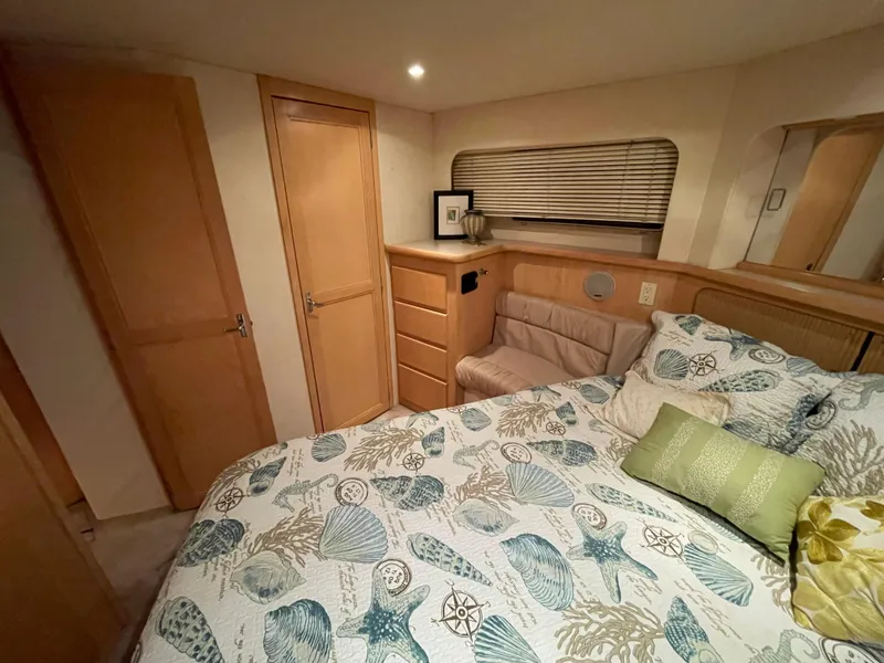 Slide: The Image of Cozy bedroom in 1996 Carver 370 Aft Cabin with nautical-themed bedding and wooden cabinetry. - 37