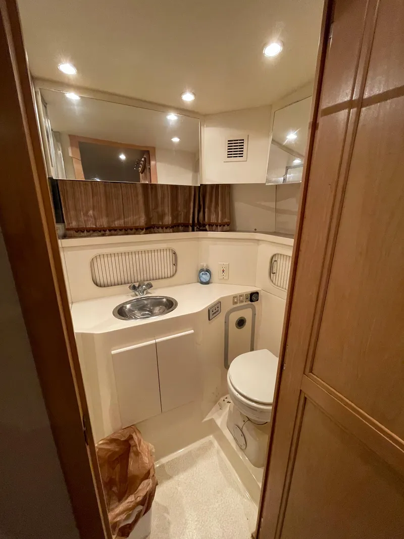 Slide: The Image of 1996 Carver 370 Aft Cabin bathroom with sink, toilet, and mirror. - 38