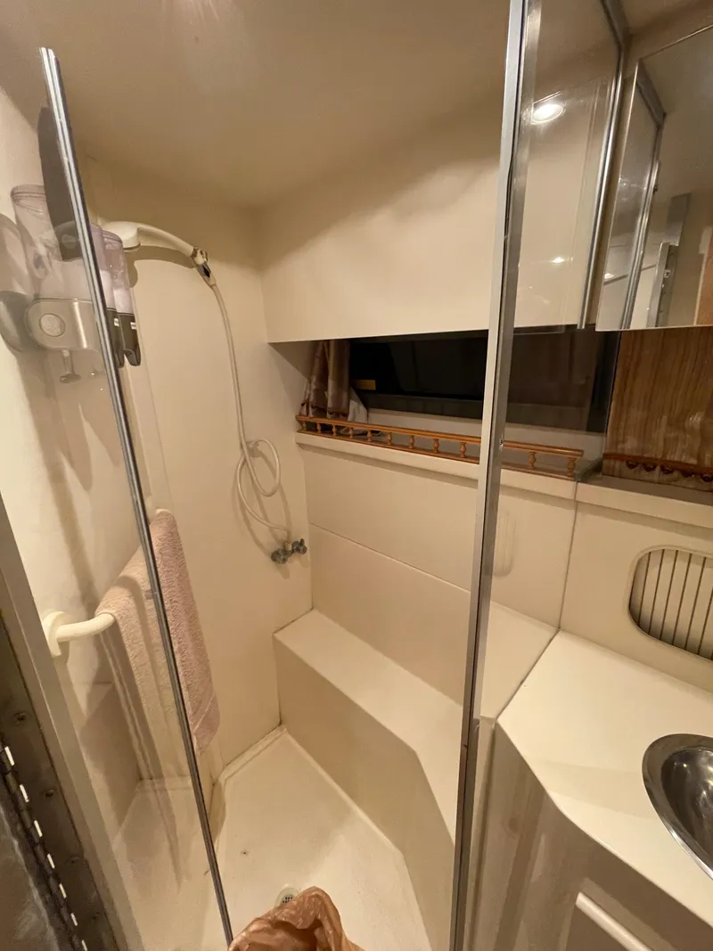 Slide: The Image of 1996 Carver 370 Aft Cabin bathroom with shower, sink, and window. - 39