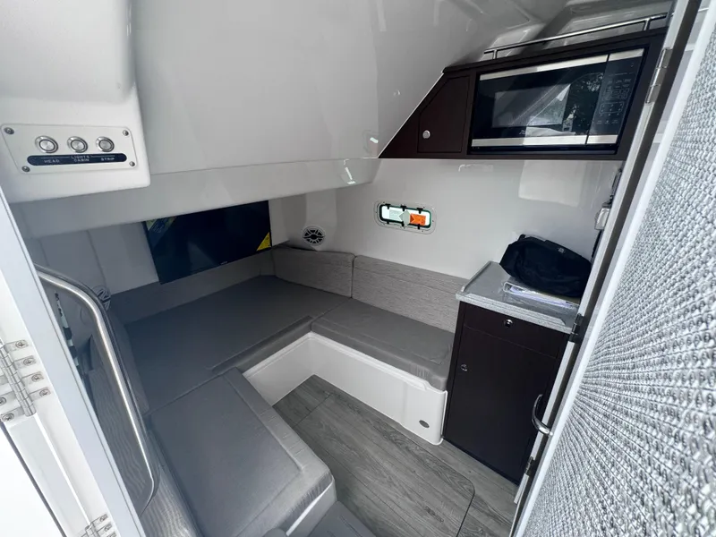 Slide: The Image of Interior cabin of 2024 Everglades 395 CC boat with seating and microwave. - 17