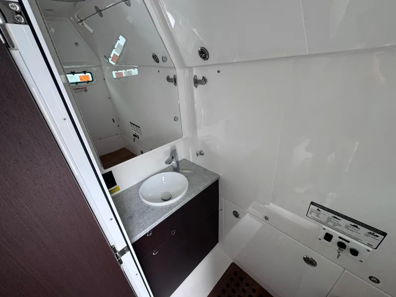 Slide: The Image of 2024 Everglades 395 CC boat bathroom with sink and mirror. - 20