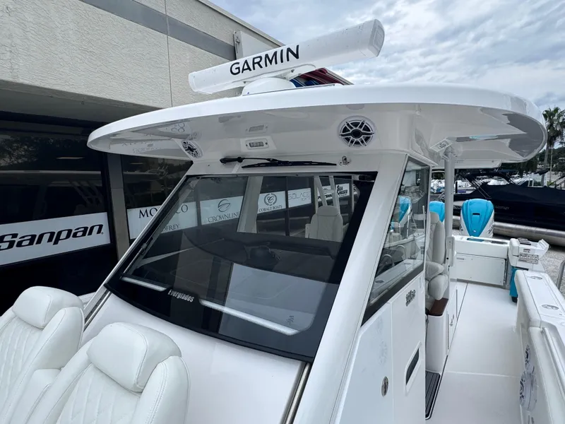 Slide: The Image of 2024 Everglades 395 CC boat with Garmin radar, sleek design, and white seating. - 24