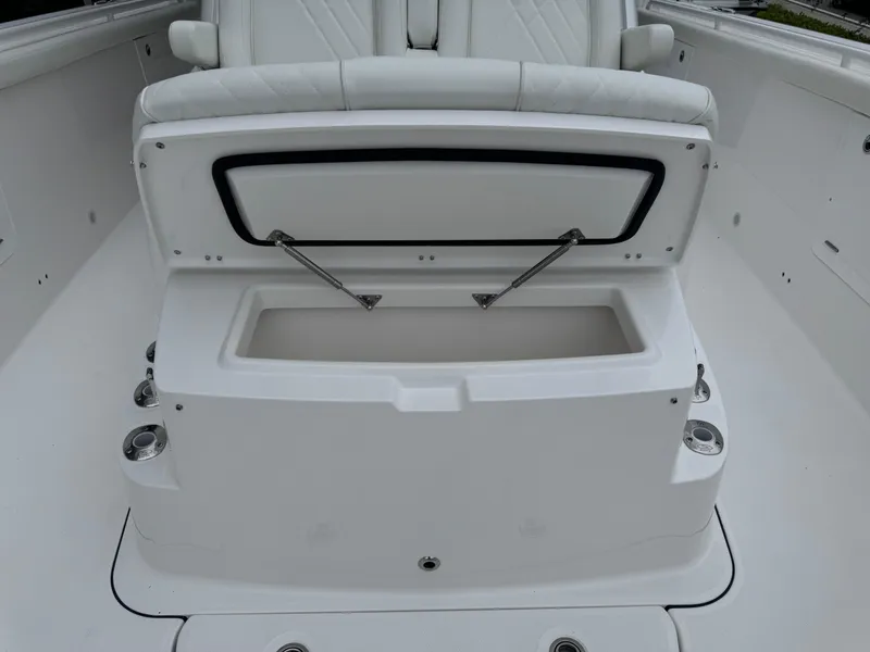 Slide: The Image of 2024 Everglades 395 CC boat seating with storage compartment open. - 26