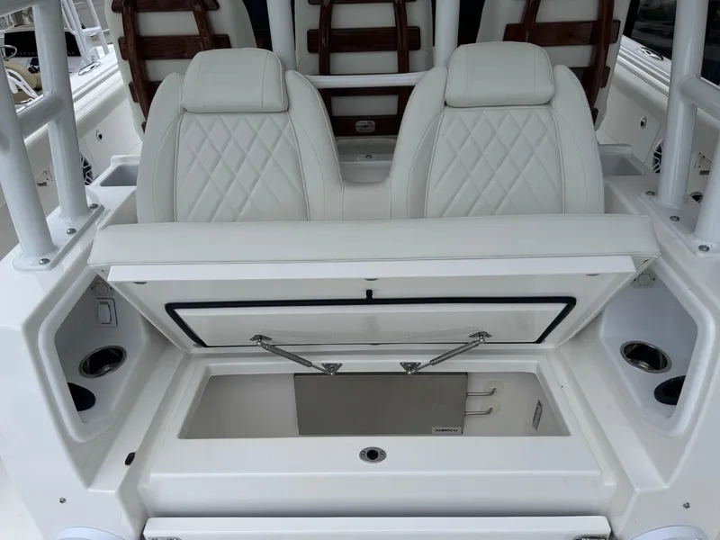 Slide: The Image of 2024 Everglades 395 CC boat interior with white leather seats and storage compartment. - 27