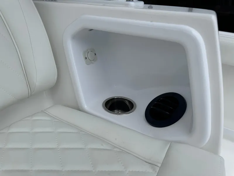 Slide: The Image of 2024 Everglades 395 CC boat interior with white leather seating and cup holder. - 30
