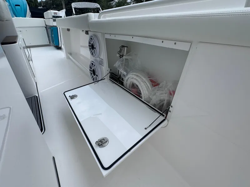 Slide: The Image of 2024 Everglades 395 CC boat storage compartment with open hatch and visible equipment. - 37