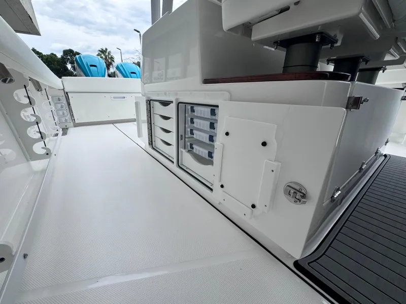 Slide: The Image of 2024 Everglades 395 CC boat interior with storage compartments and seating. - 40