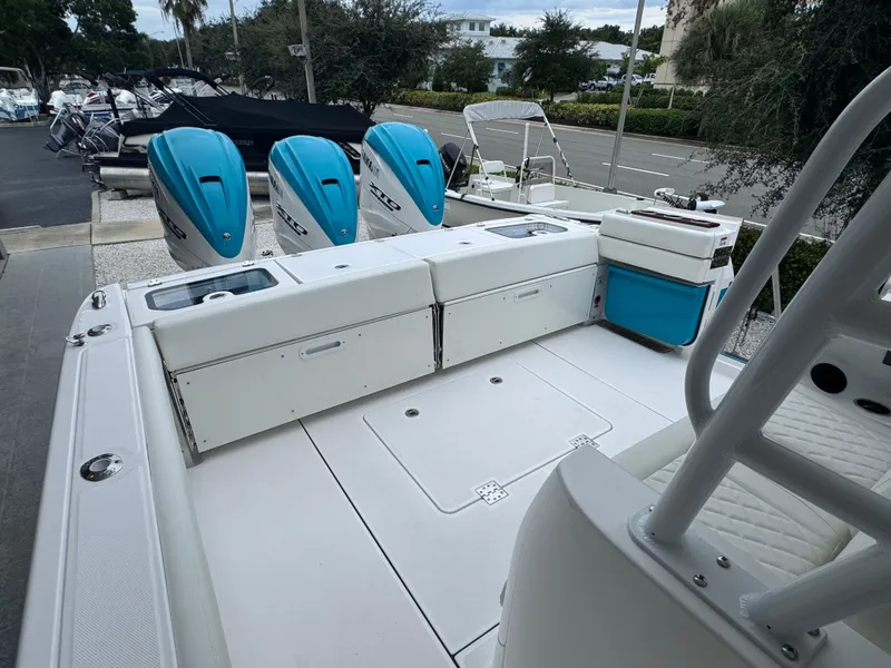 Slide: The Image of 2024 Everglades 395 CC boat with triple outboard engines, spacious deck, and seating area. - 47