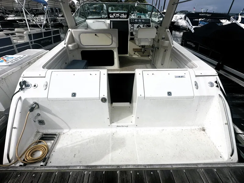 Slide: The Image of 1989 Tiara Yachts 310 SC boat interior at dock, showing seating and storage compartments. - 3