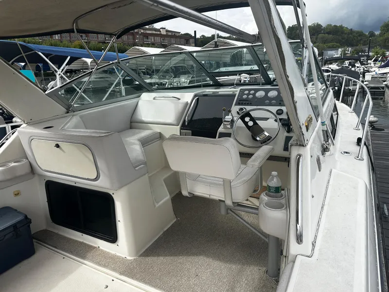Slide: The Image of 1989 Tiara Yachts 310 SC boat interior with helm and seating at marina. - 6