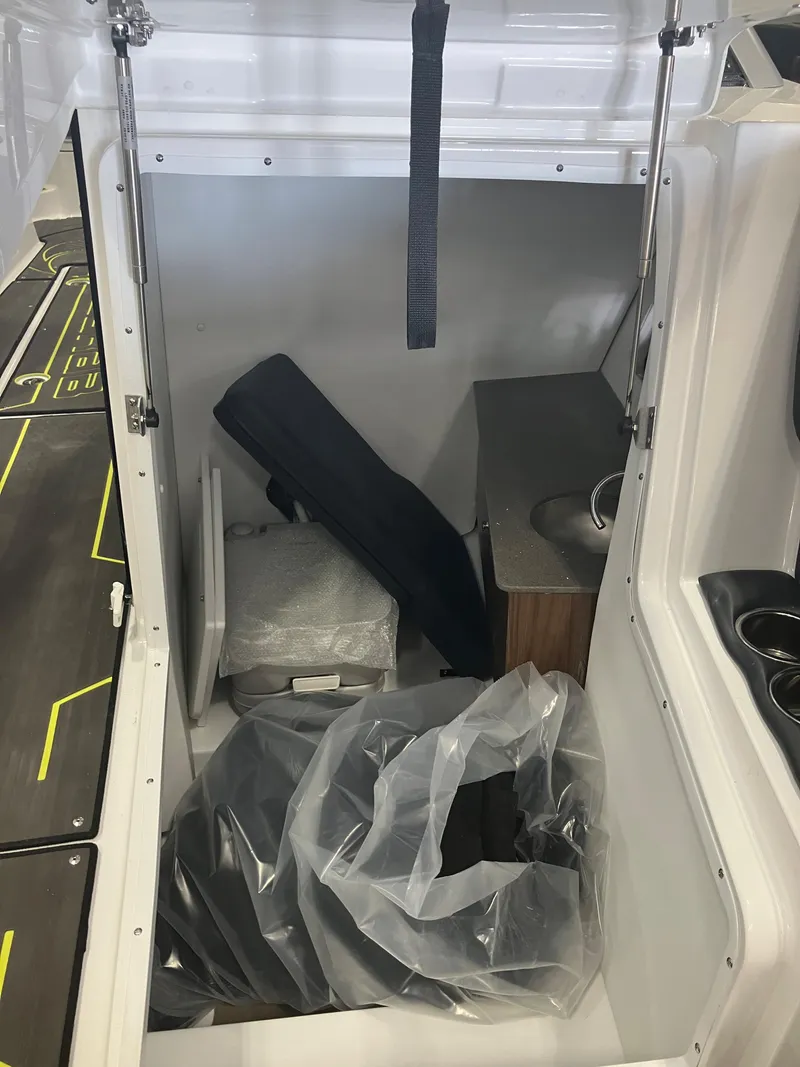 Slide: The Image of 2024 Scarab 285 boat interior storage compartment with various items. - 10