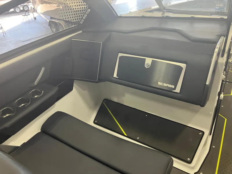 Slide: The Image of 2024 Scarab 285 boat interior with black seating and storage compartments. - 8