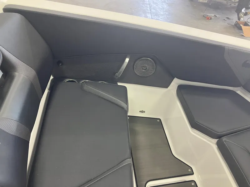 Slide: The Image of 2024 Scarab 285 boat interior with black seating in a storage facility. - 13