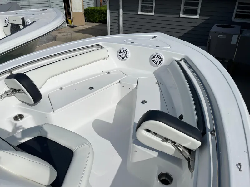 Slide: The Image of 2024 Tidewater 198 CC boat interior with white seating and built-in speakers. - 6