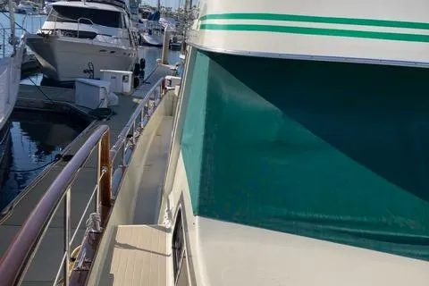 Slide: The Image of 1977 Tollycraft 48' Cockpit Motor Yacht docked at marina, side view. - 2