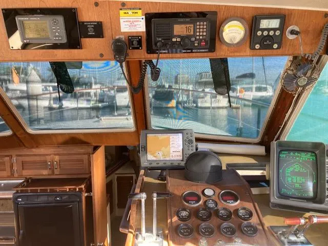 Slide: The Image of 1977 Tollycraft 48' Cockpit Motor Yacht helm with navigation instruments and marina view. - 4