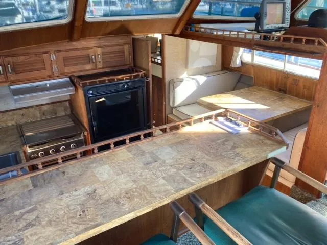 Slide: The Image of 1977 Tollycraft 48' Cockpit Motor Yacht interior with kitchen and dining area. - 7