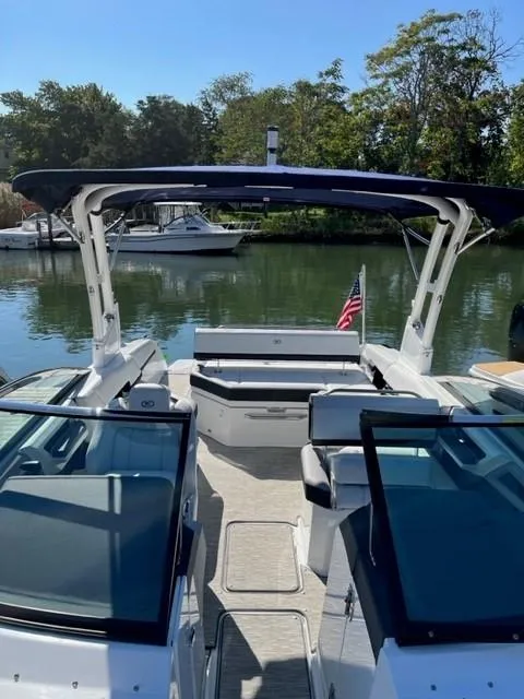 Slide: The Image of 2021 Cobalt R6 boat docked on a serene lake with lush greenery. - 7