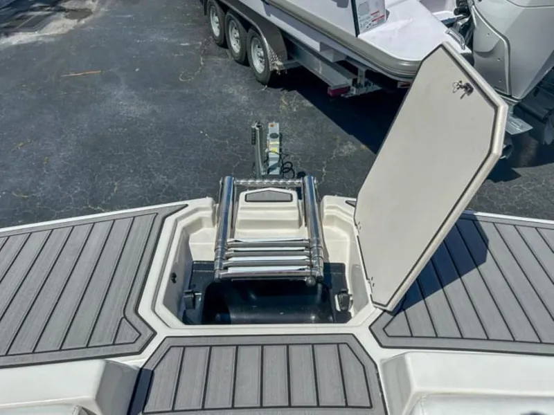 Slide: The Image of 2024 Starcraft SVX 231 OB DH boat with open storage compartment and ladder. - 2