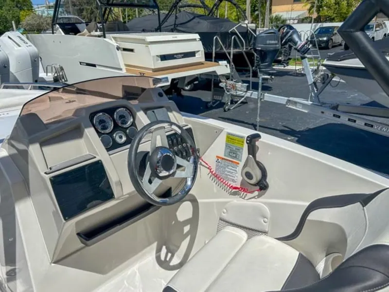 Slide: The Image of 2024 Starcraft SVX 231 OB DH boat cockpit with steering wheel and control panel. - 5