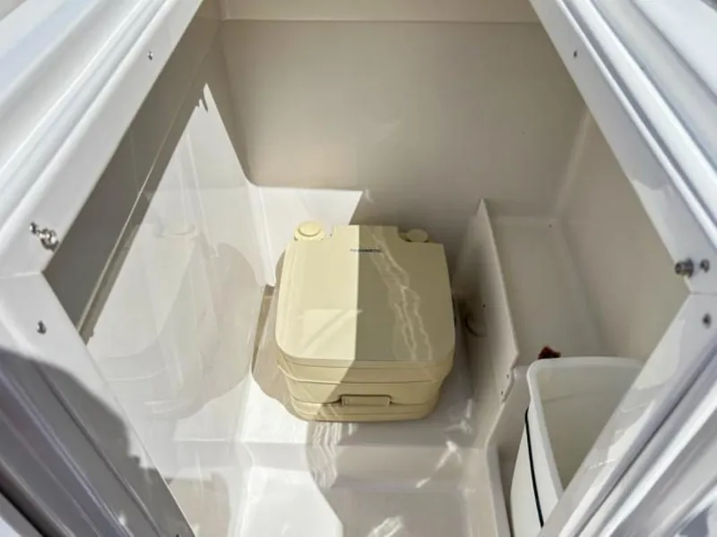 Slide: The Image of 2024 Starcraft SVX 231 OB DH boat interior storage compartment with portable toilet. - 9