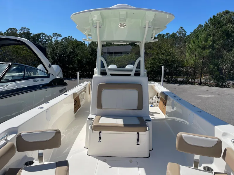 Slide: The Image of 2024 Sea Born LX 26 boat with seating and T-top in a parking lot. - 13