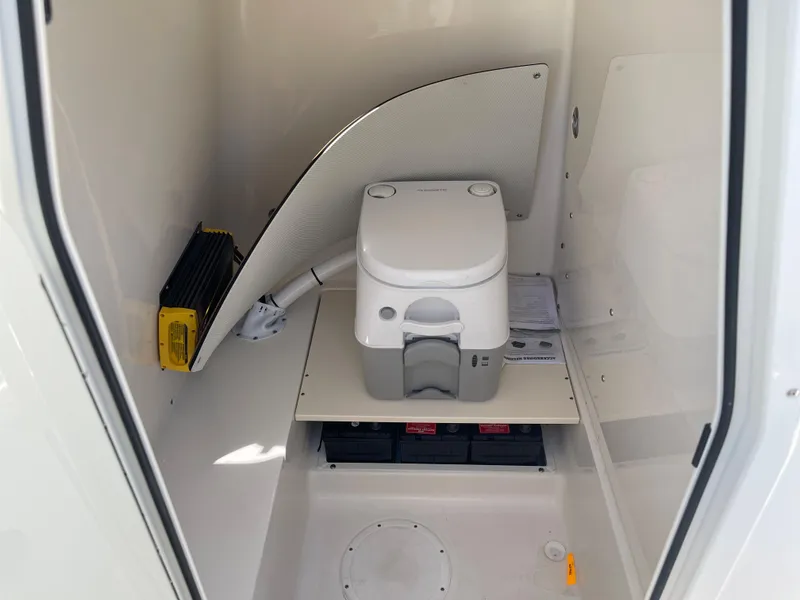 Slide: The Image of 2024 Sea Born LX 26 boat interior with portable toilet and storage area. - 15