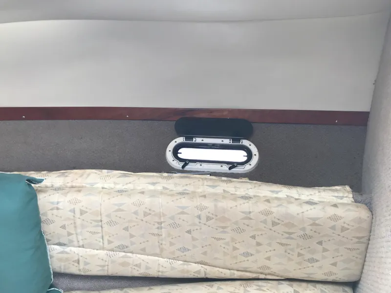 Slide: The Image of Interior cabin of a 2002 Four Winns 245 Sundowner boat with a small window. - 16