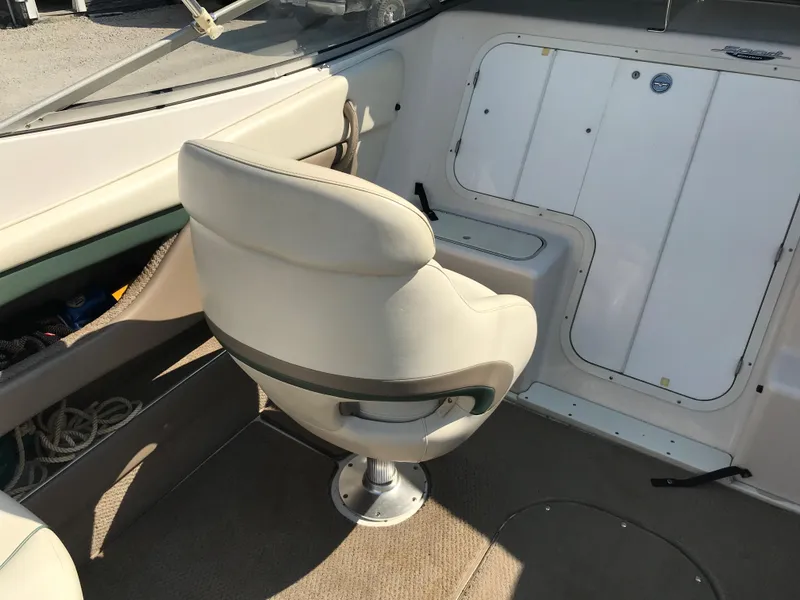 Slide: The Image of 2002 Four Winns 245 Sundowner boat interior with captain's chair and storage compartments. - 5