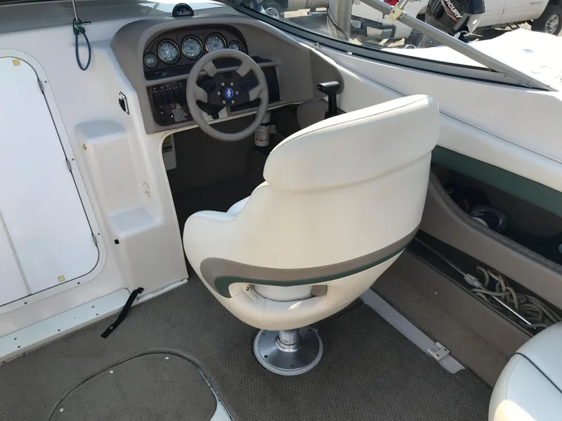 Slide: The Image of 2002 Four Winns 245 Sundowner boat cockpit with steering wheel and captain's chair. - 8