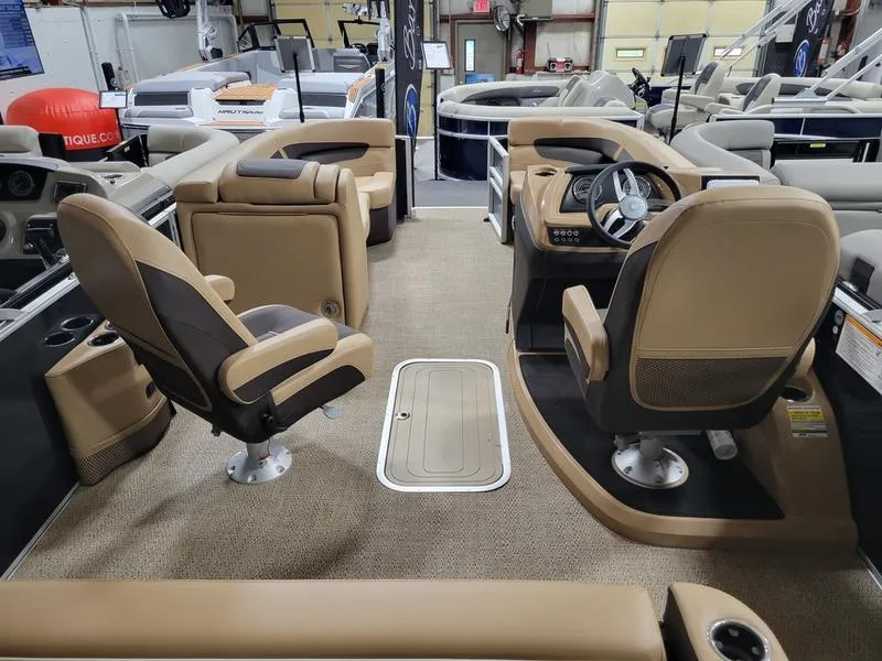 Slide: The Image of 2024 Barletta C22UC pontoon boat interior with tan seating and steering console. - 13